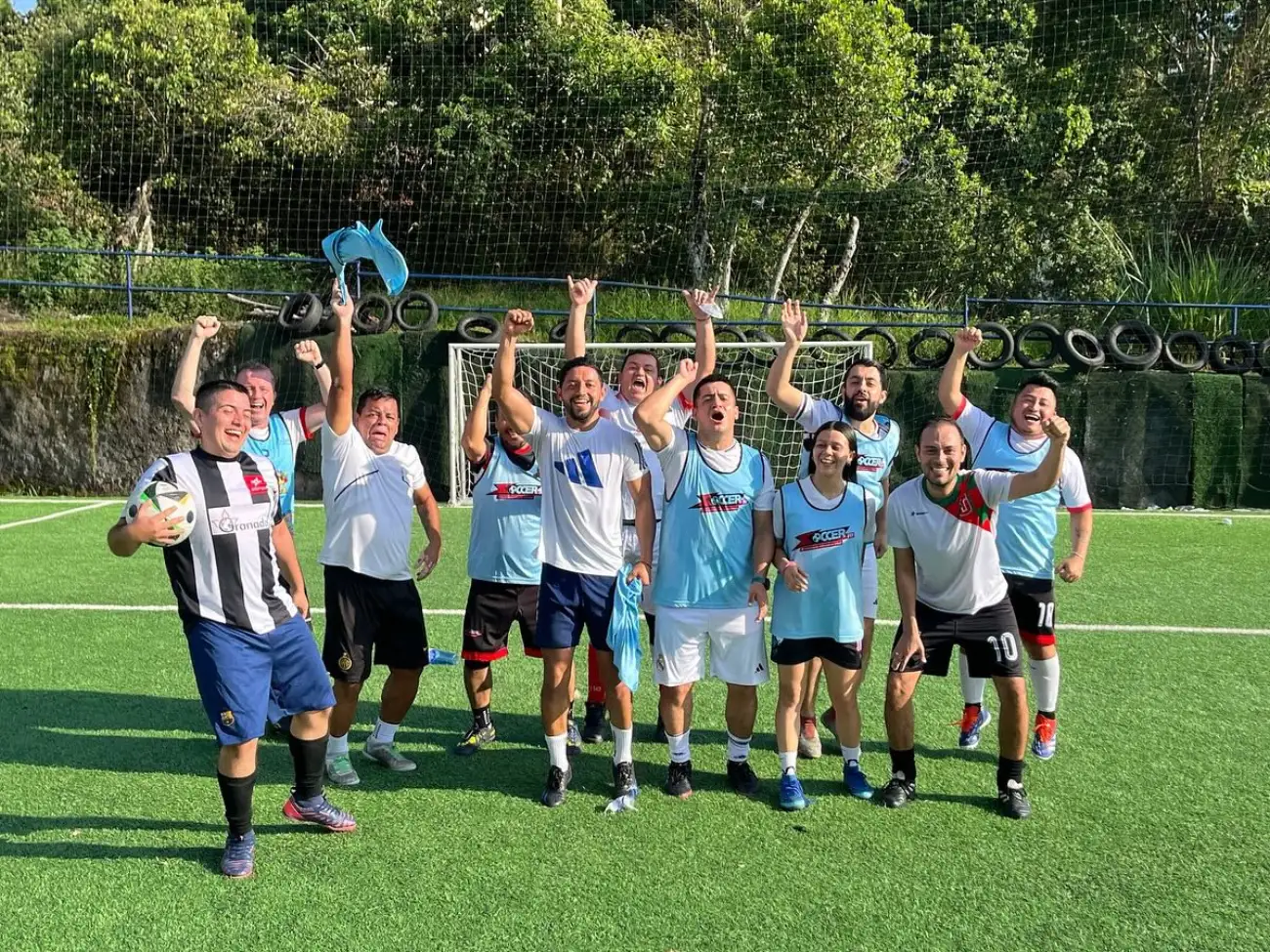 Equipo de Soccer Fit celebrando con los brazos en alto sobre la cancha